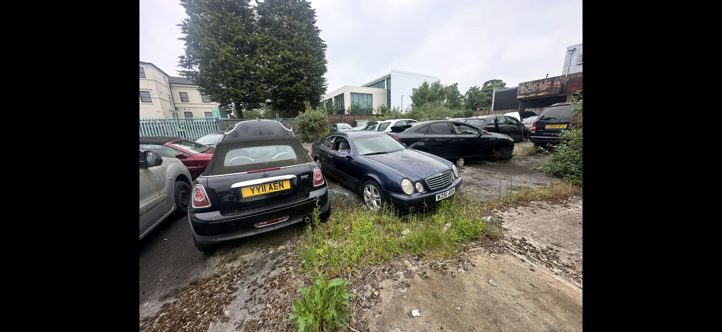 Multiple abandoned vehicles in a commercial yard awaiting removal – Leicester